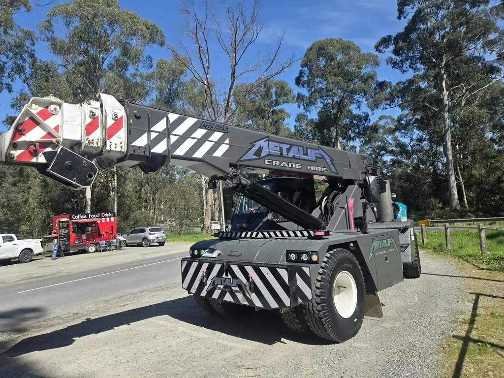 Metalift Crane Hire pick and carry crane parked on a bush road with the Metalift name on the boom