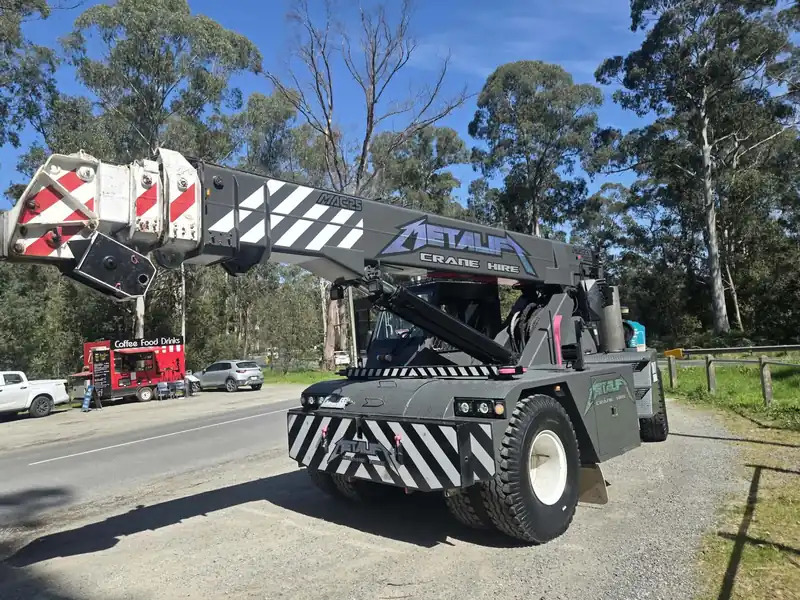 Metalift Crane Hire pick and carry crane parked on a bush road with the Metalift name on the boom
